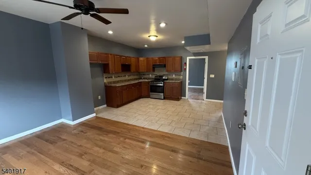 a open kitchen with kitchen island a stove a refrigerator and a sink