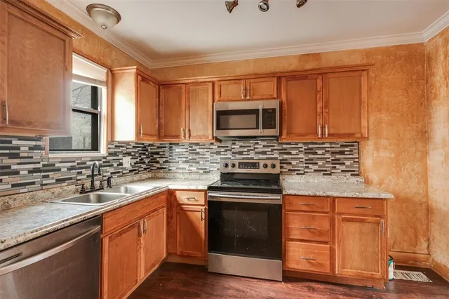 a kitchen with stainless steel appliances granite countertop a sink stove and microwave
