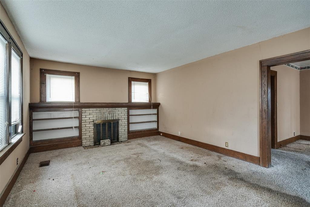 3112 10th Street Wichita Falls, TX 76309 - Photo 5 of 31 an empty room with a fireplace and windows