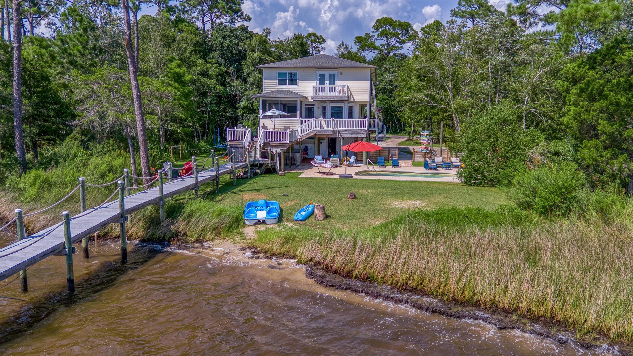 7121 Wells Avenue Navarre, FL 32566 - Photo 119 of 125 a view of a house with a yard and potted plants