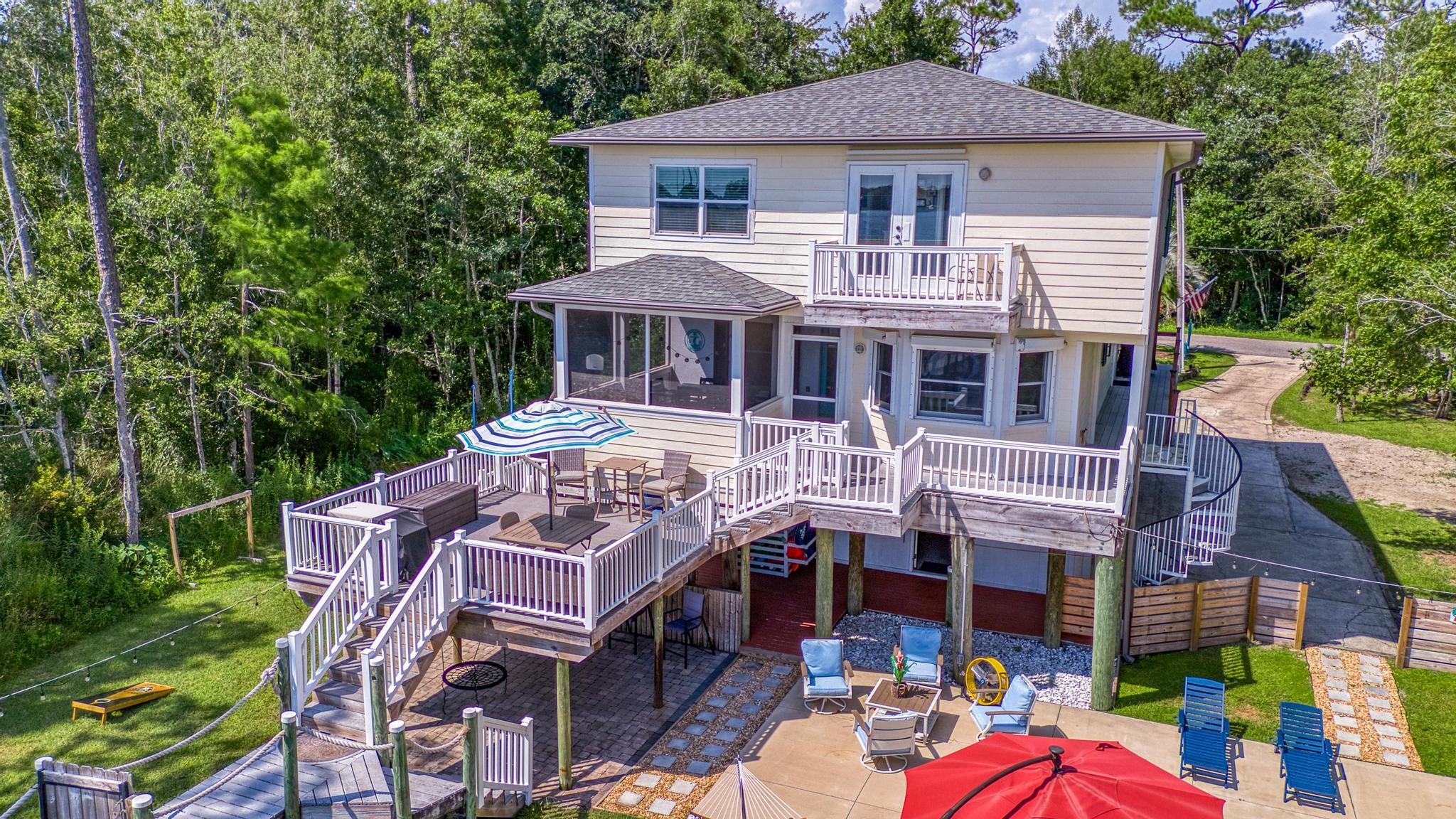 7121 Wells Avenue Navarre, FL 32566 - Photo 121 of 125 a front view of a house with a garden and deck
