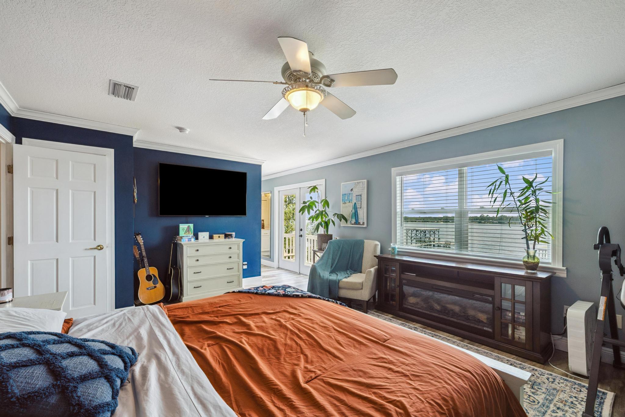 7121 Wells Avenue Navarre, FL 32566 - Photo 21 of 125 a bedroom with a bed and a flat tv screen on dresser