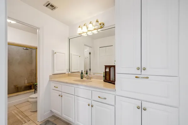 a living room with furniture kitchen view and a chandelier