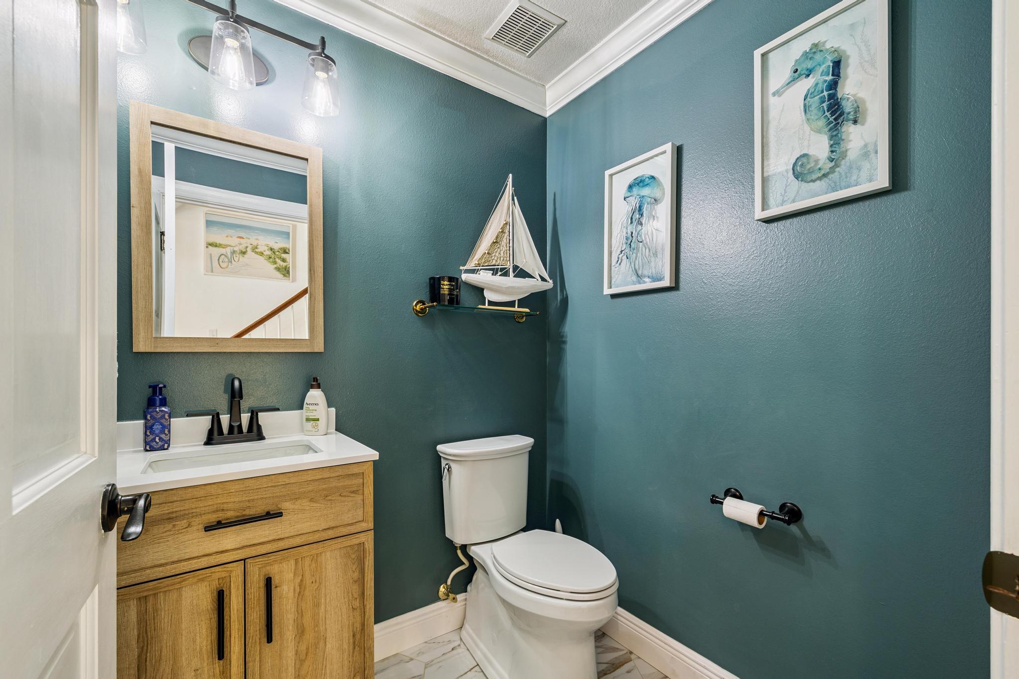 7121 Wells Avenue Navarre, FL 32566 - Photo 31 of 125 a bathroom with a toilet sink vanity and mirror