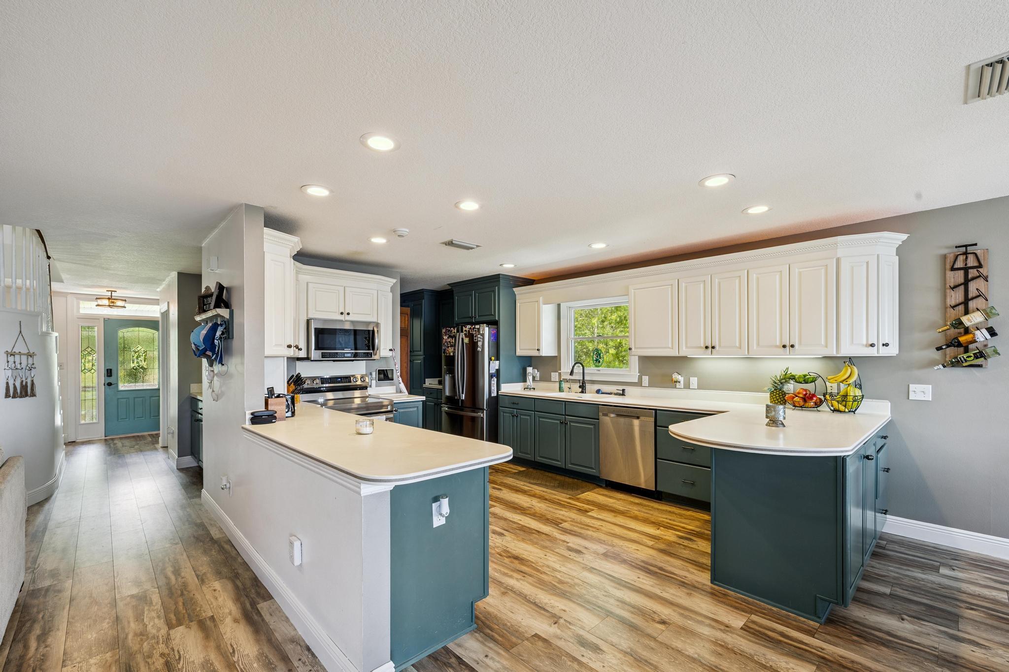 7121 Wells Avenue Navarre, FL 32566 - Photo 36 of 125 a kitchen with a sink stove and wooden cabinets
