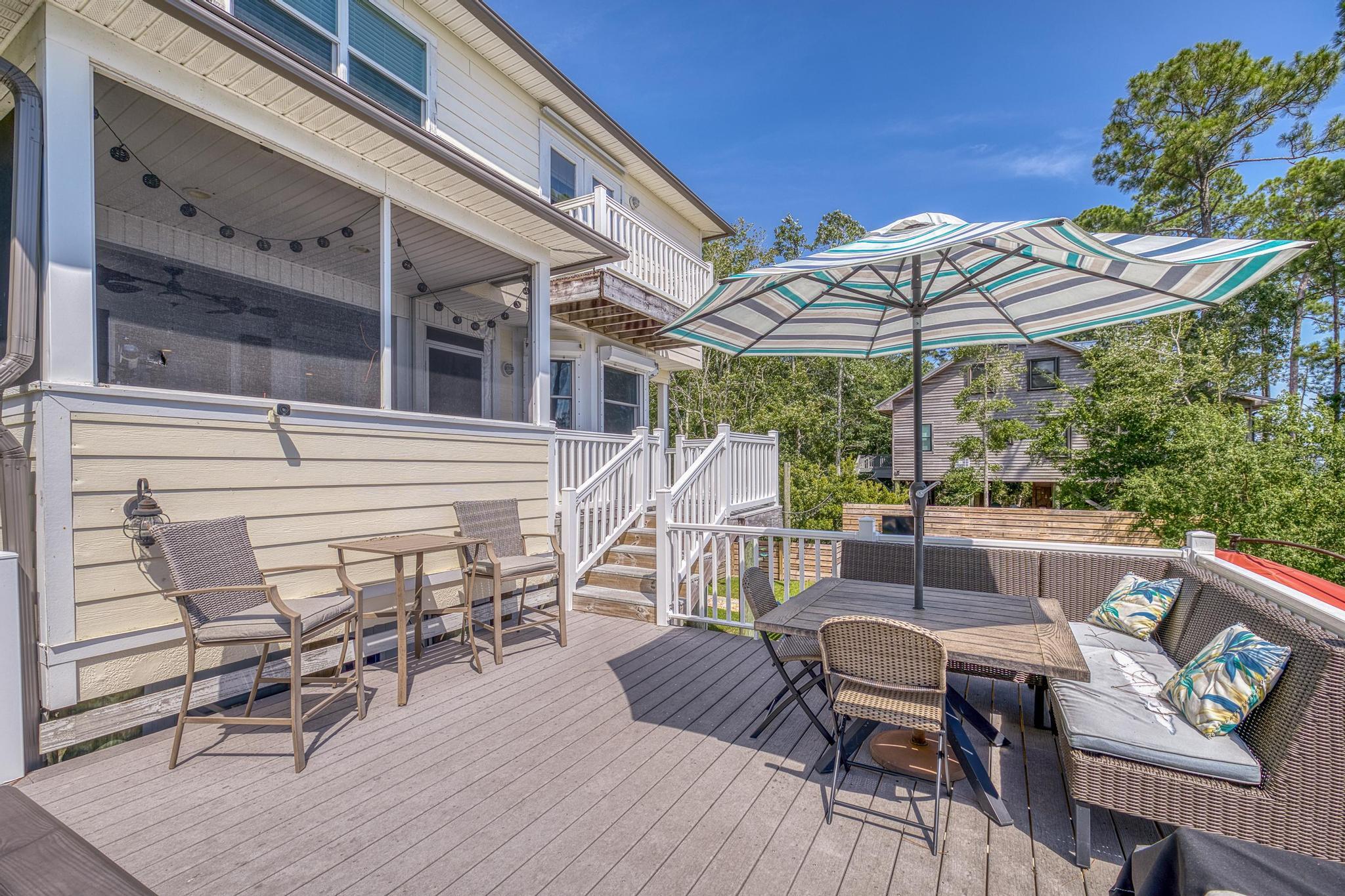 7121 Wells Avenue Navarre, FL 32566 - Photo 71 of 125 a view of deck with table and chairs under an umbrella with a barbeque