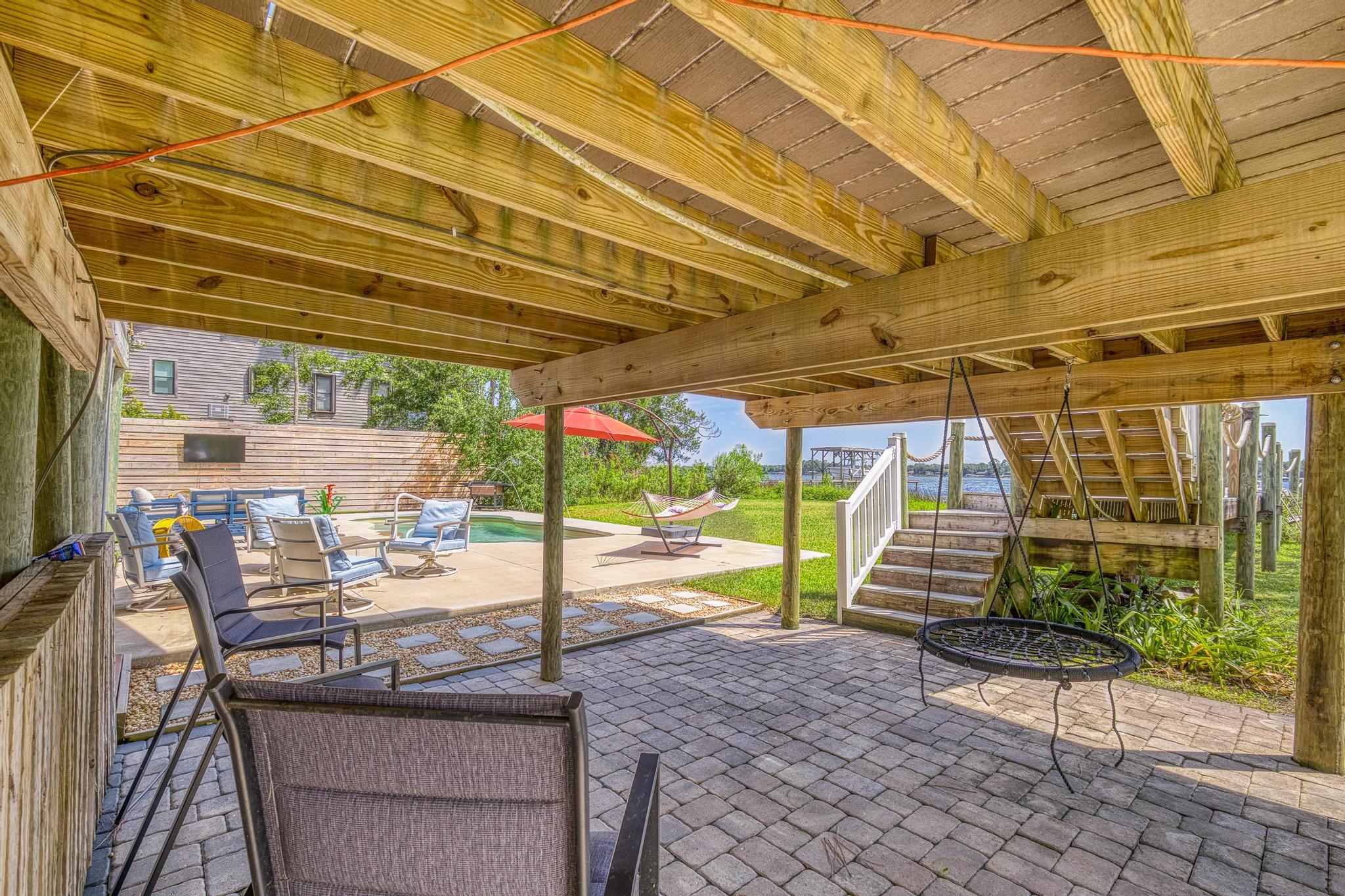 7121 Wells Avenue Navarre, FL 32566 - Photo 76 of 125 a view of a patio with a table and chairs under an umbrella