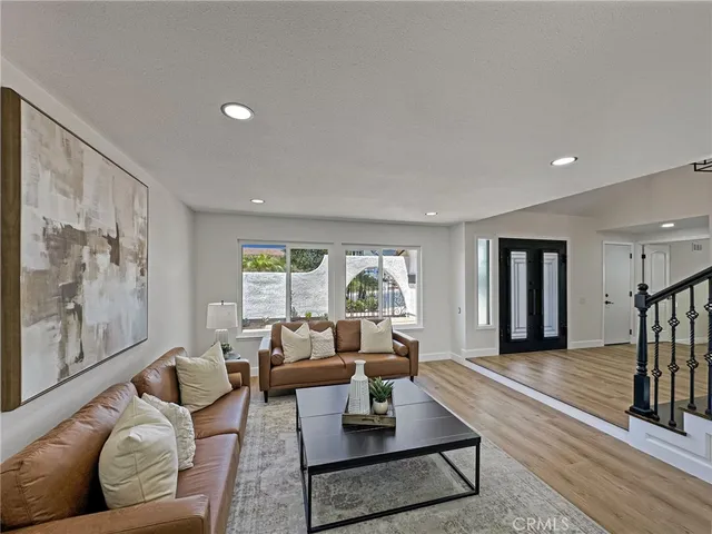 a living room with furniture large window and a wooden floor