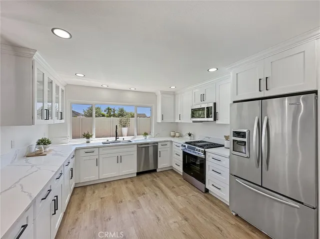 a kitchen with white cabinets and stainless steel appliances