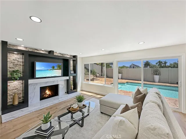 a living room with furniture a flat screen tv and a fireplace