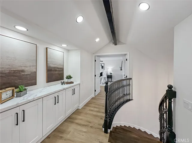 a large white kitchen with a sink and wooden floor