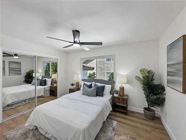 a bedroom with a large bed and a potted plant