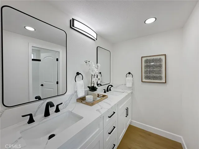a bathroom with double vanity sinks and a mirror