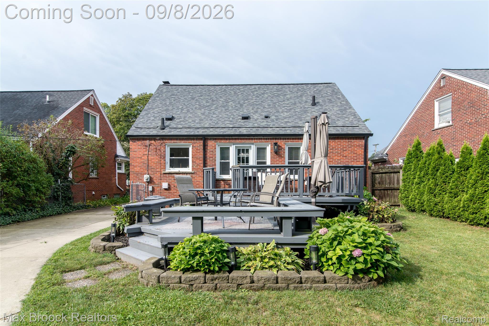 1533 Mansfield Road Birmingham, MI 48009 - Photo 35 of 48 Brick exterior featuring a multi-level deck, shingle roof, and manicured landscaping