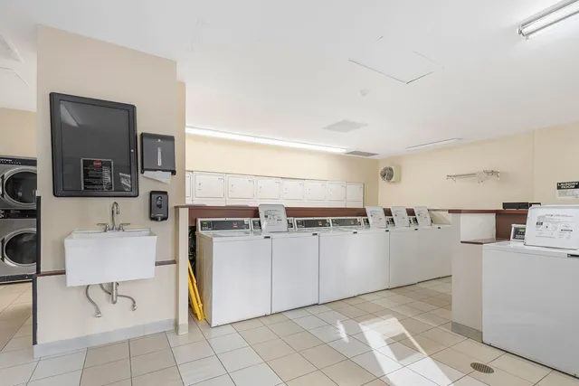a kitchen with a refrigerator and white cabinets