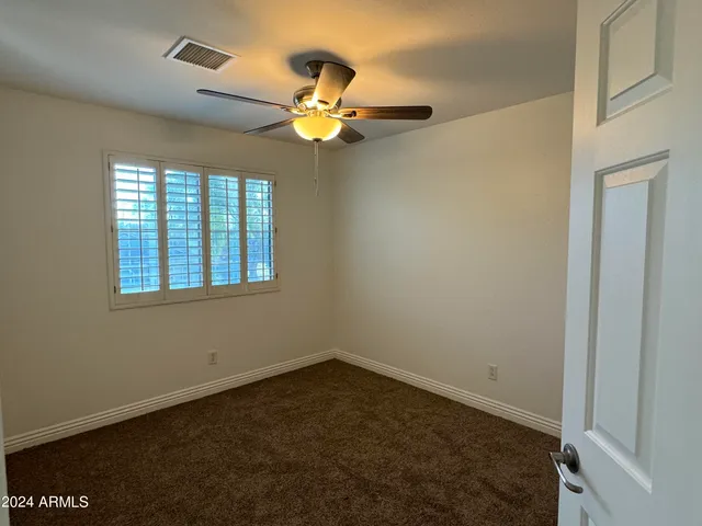 en empty room with windows and chandelier