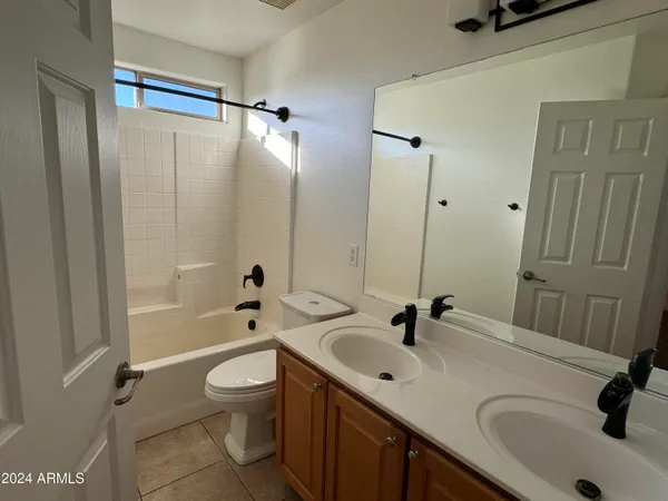 a bathroom with a sink a toilet a mirror and shower