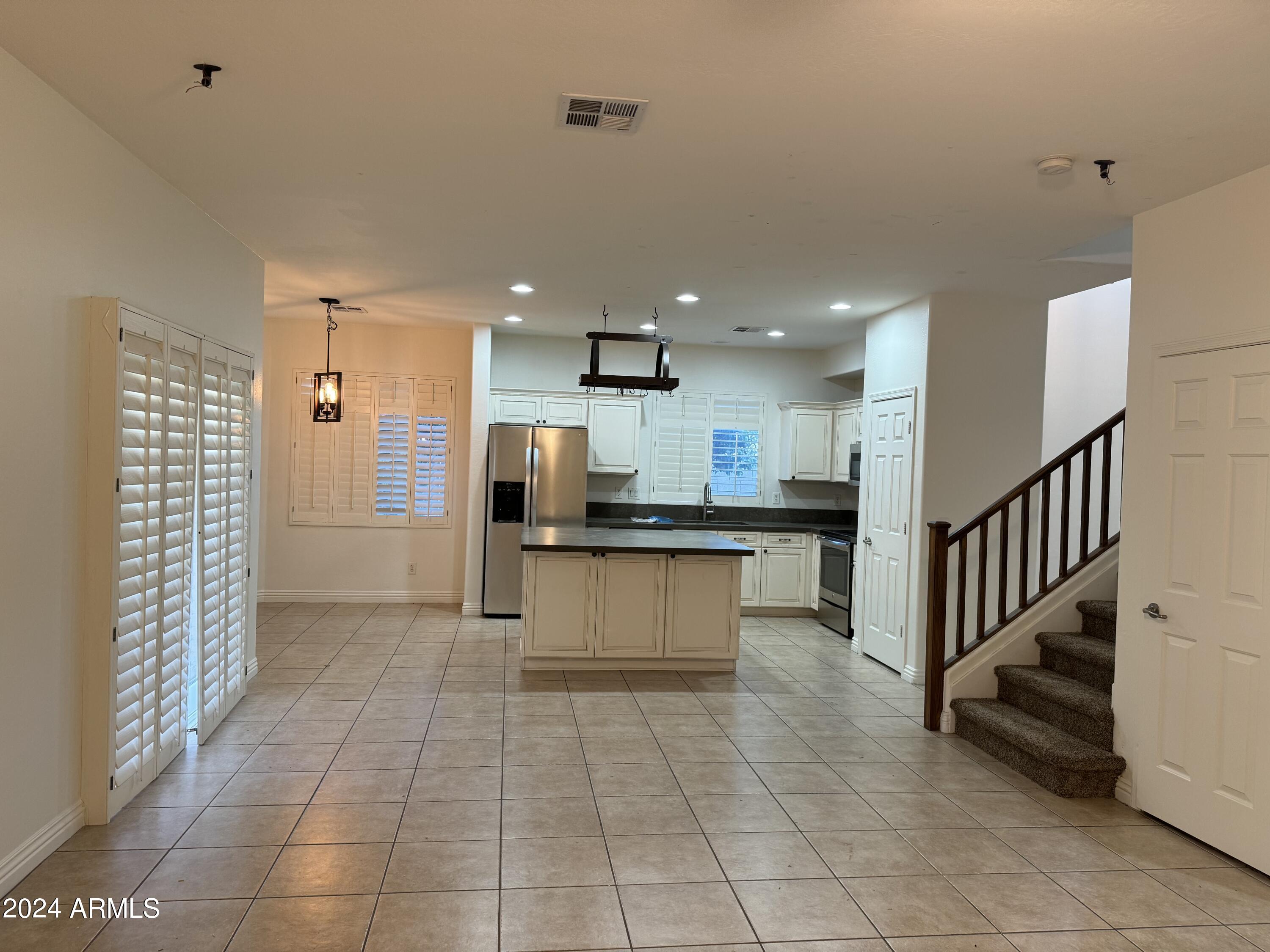 4576 East Sundance Avenue Gilbert, AZ 85297 - Photo 5 of 23 a kitchen with stainless steel appliances kitchen island granite countertop a refrigerator and a sink