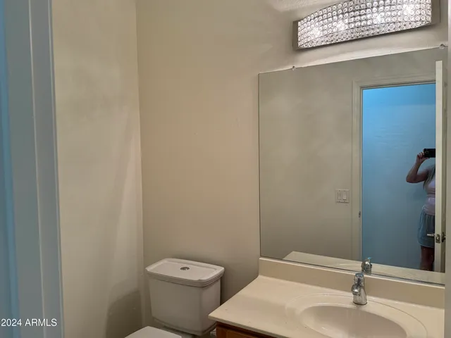 a bathroom with a sink a toilet and mirror