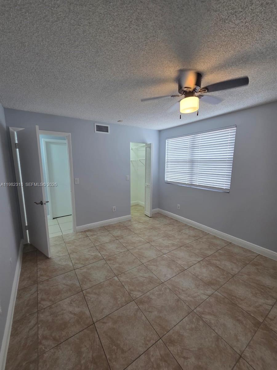 1241 Southwest 46th Avenue, Unit 1006 Pompano Beach, FL 33069 - Photo 4 of 9 a view of an empty room with a window