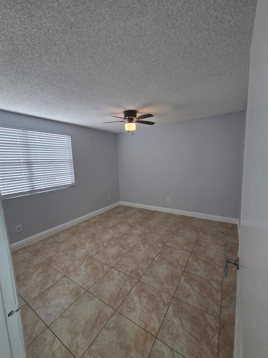 1241 Southwest 46th Avenue, Unit 1006 Pompano Beach, FL 33069 - Photo 7 of 9 an empty room with windows