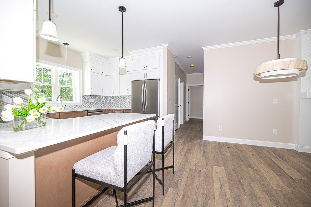 10 Meadowview Lane, Unit B Salisbury, MA 01952 - Photo 15 of 31 a kitchen with stainless steel appliances a dining table chairs refrigerator and sink