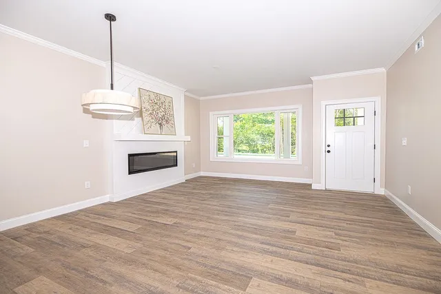 a view of empty room with wooden floor and window