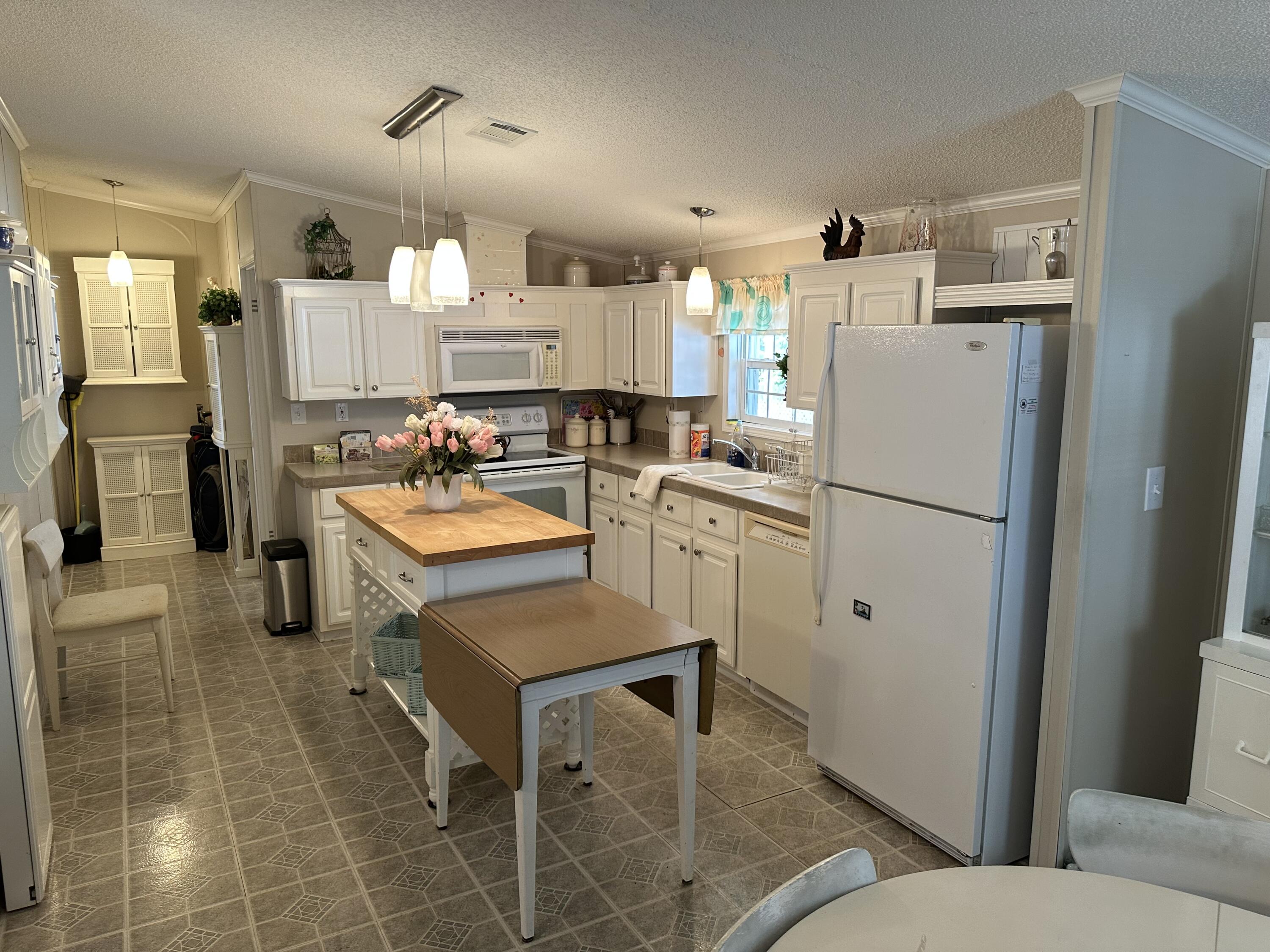 14567 Sunset Drive Delray Beach, FL 33445 - Photo 11 of 32 a kitchen with refrigerator and cabinets