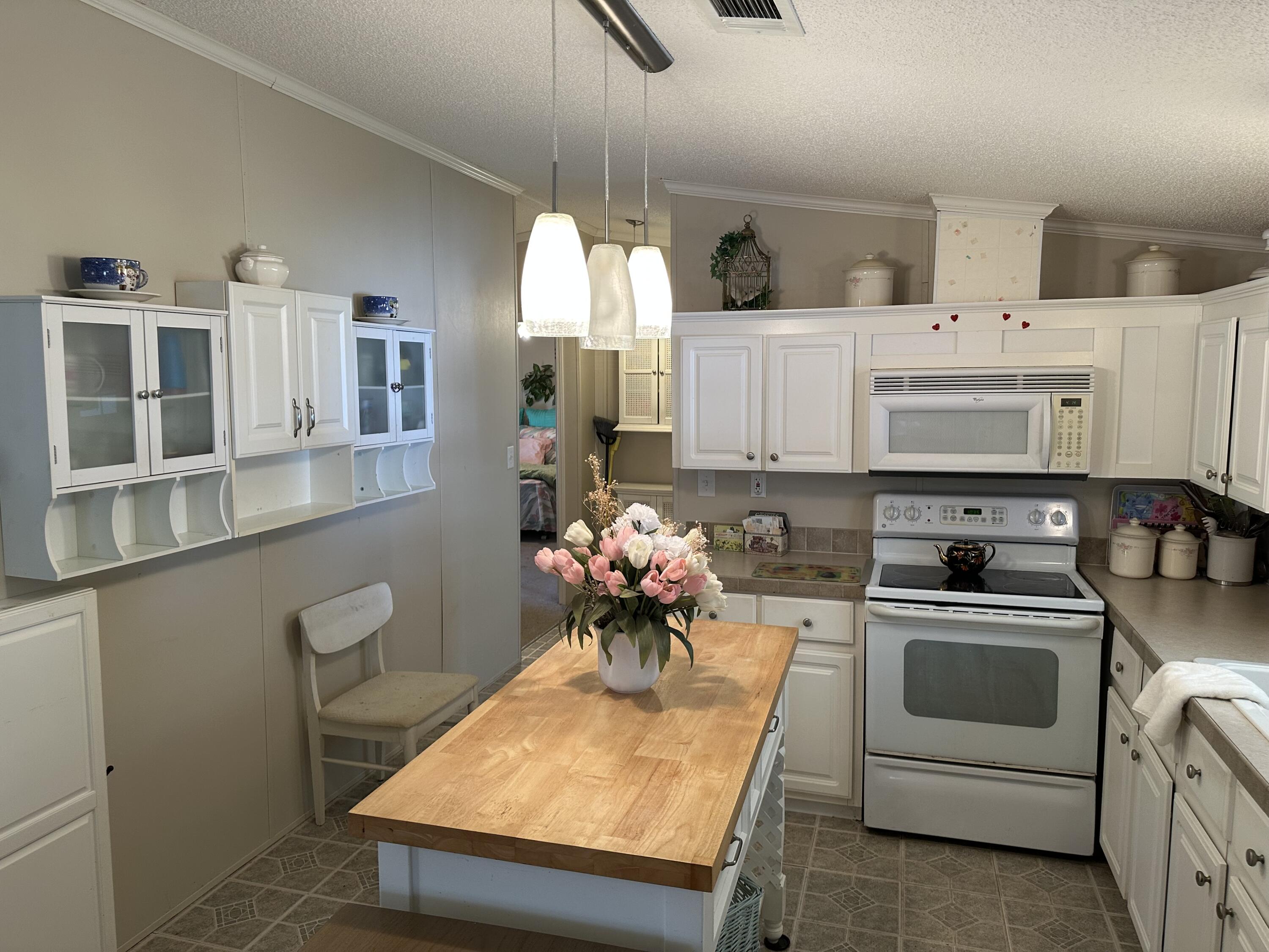 14567 Sunset Drive Delray Beach, FL 33445 - Photo 12 of 32 a kitchen with stainless steel appliances a white stove top oven and a white cabinets