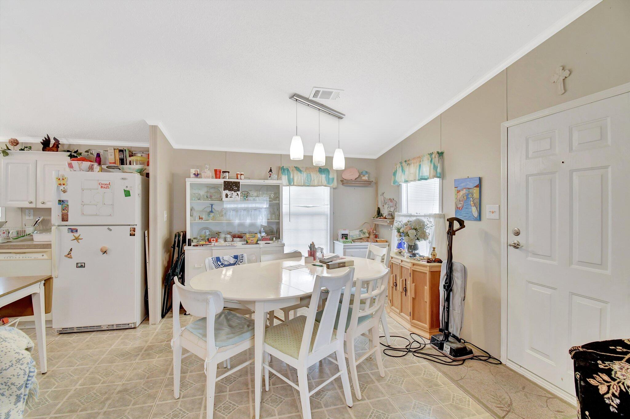 14567 Sunset Drive Delray Beach, FL 33445 - Photo 13 of 32 a view of a dining room with furniture and a chandelier