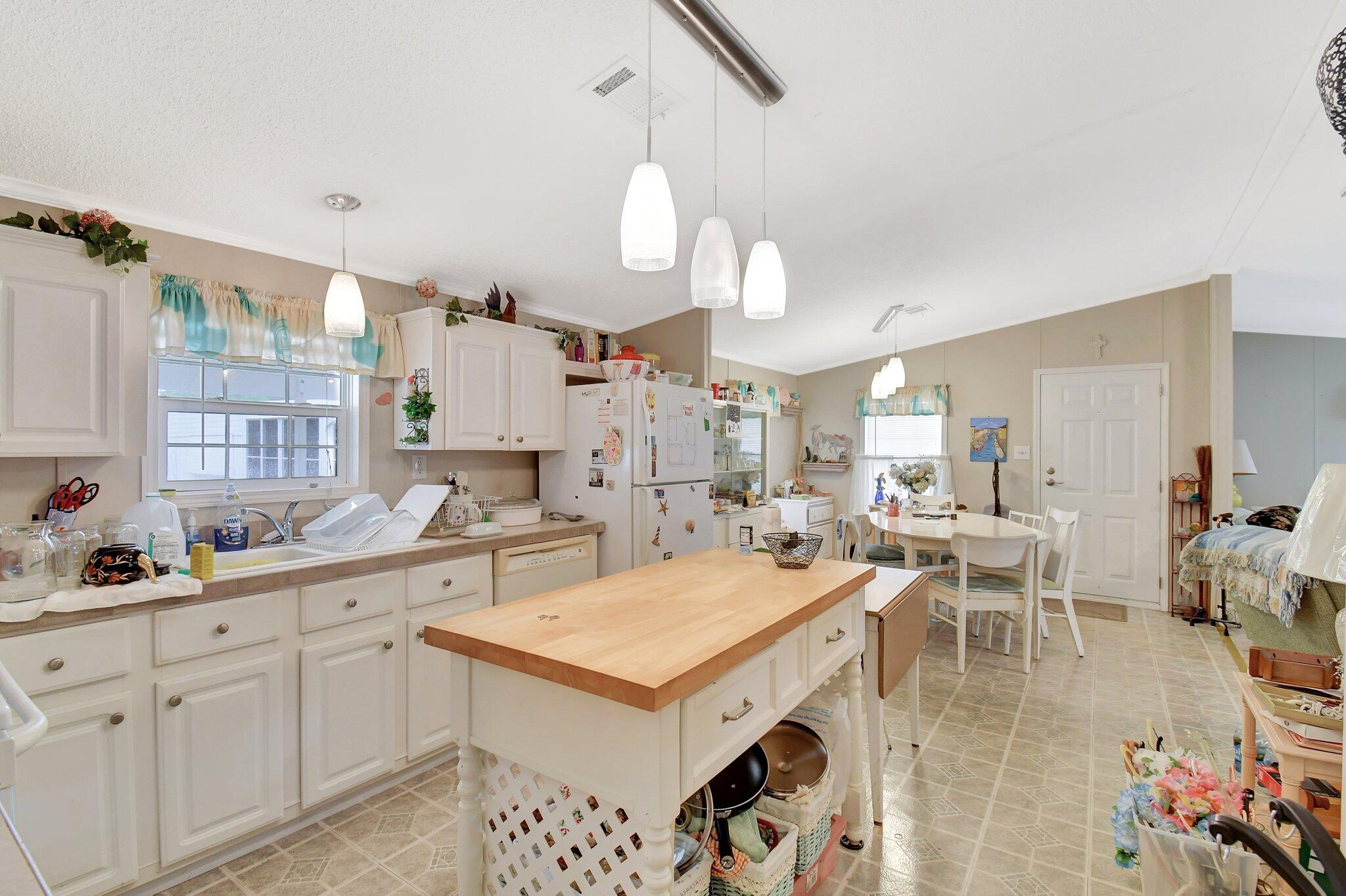 14567 Sunset Drive Delray Beach, FL 33445 - Photo 15 of 32 a kitchen with a stove a kitchen island a sink and white cabinets
