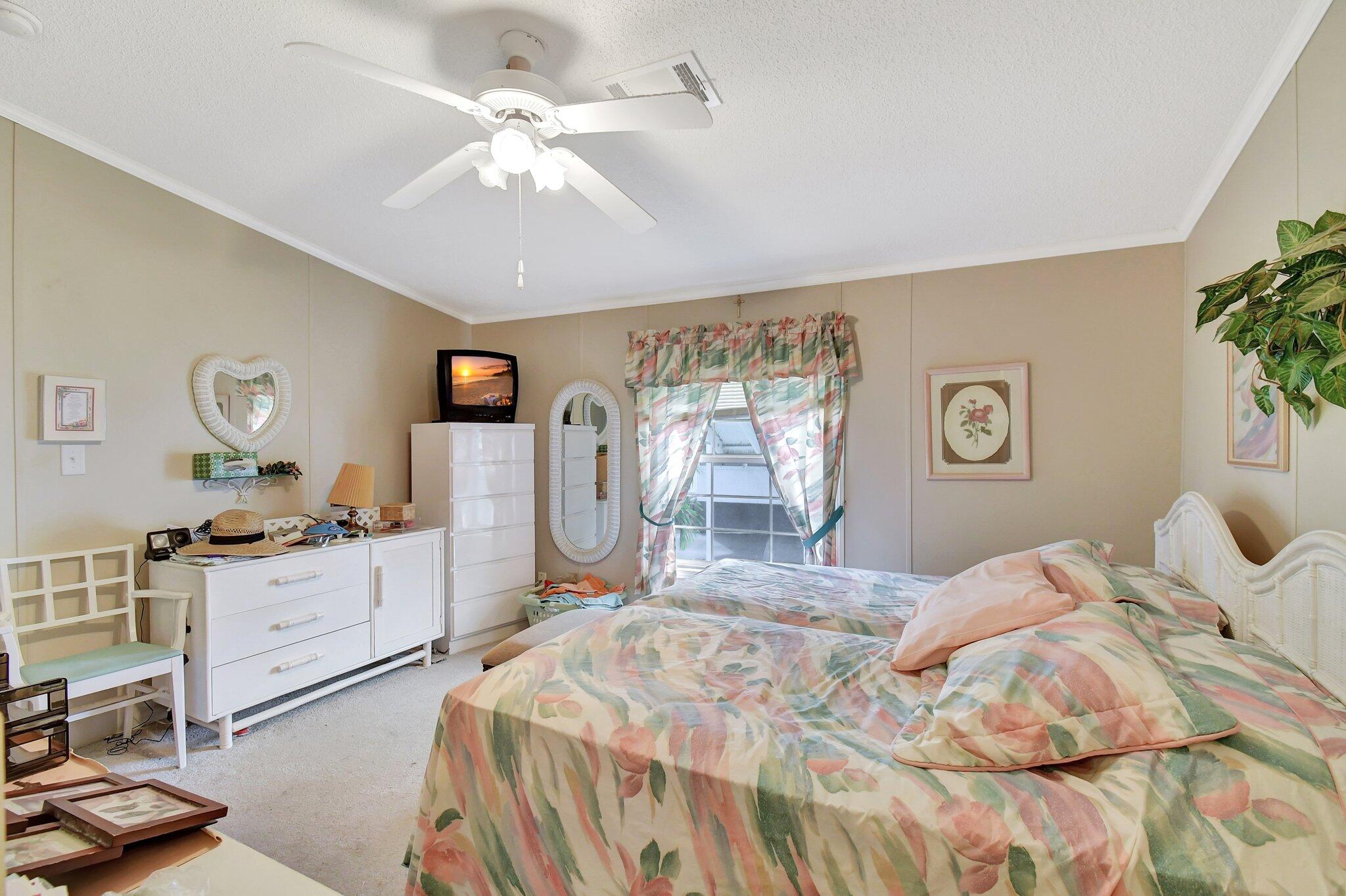 14567 Sunset Drive Delray Beach, FL 33445 - Photo 18 of 32 a bedroom with a bed and a chandelier