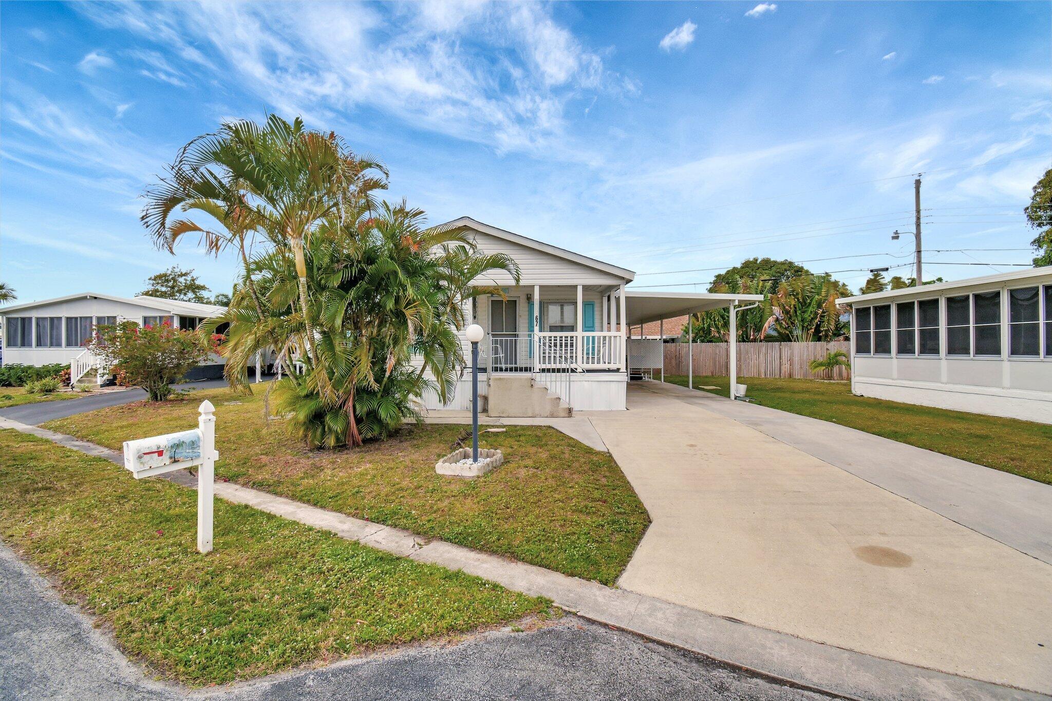 14567 Sunset Drive Delray Beach, FL 33445 - Photo 2 of 32 a front view of a house with garden