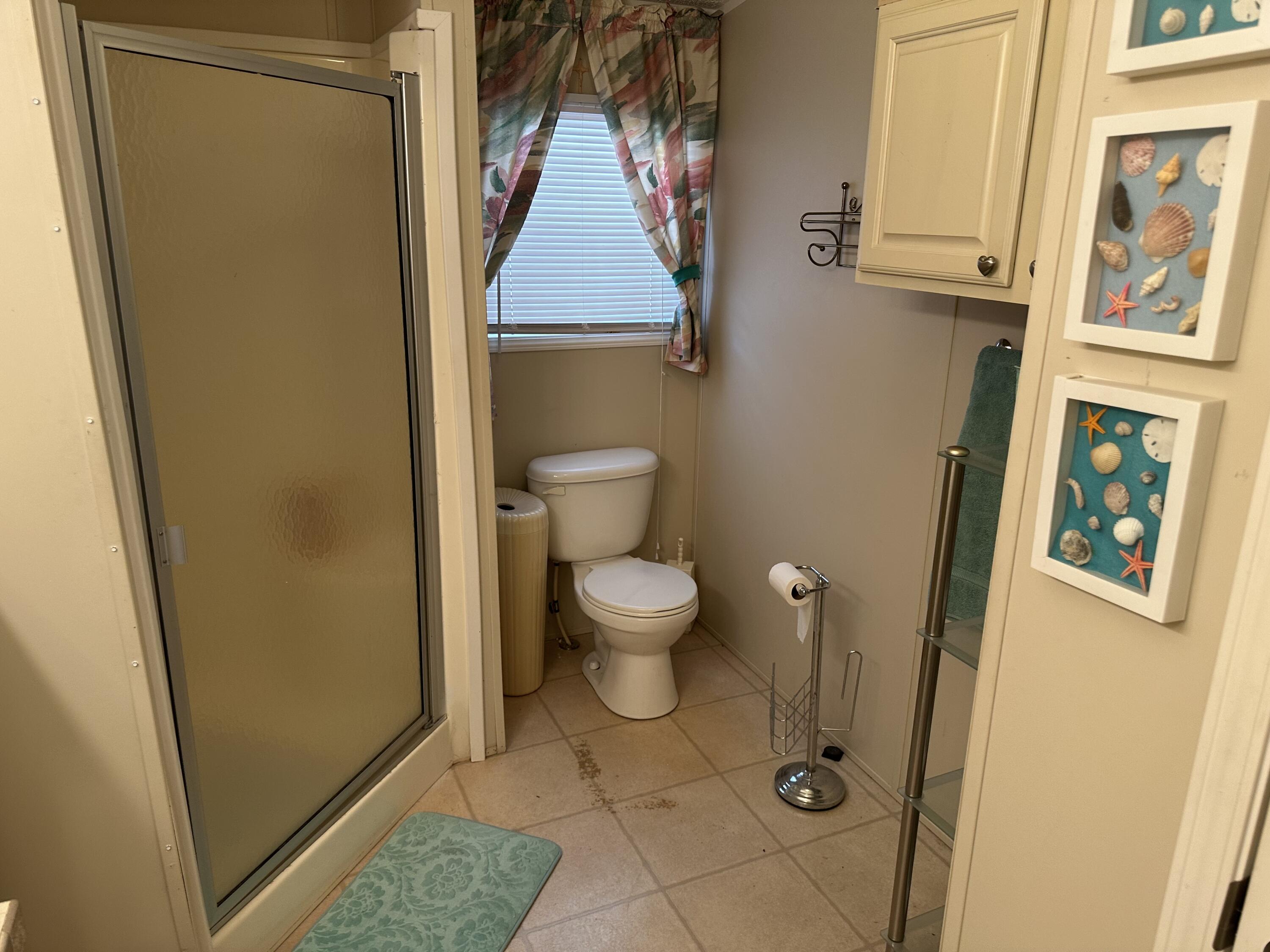 14567 Sunset Drive Delray Beach, FL 33445 - Photo 29 of 32 a bathroom with a toilet and a shower curtain