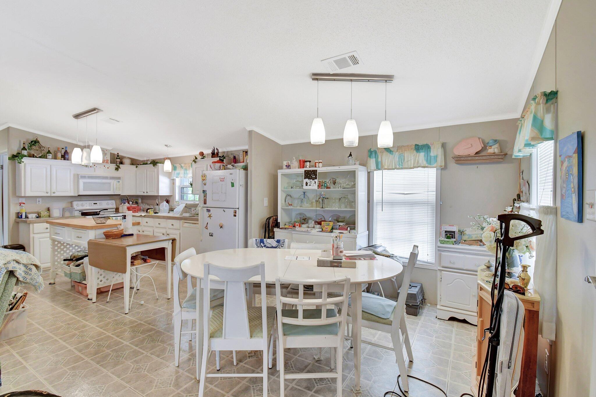 14567 Sunset Drive Delray Beach, FL 33445 - Photo 9 of 32 a dining room with furniture and a chandelier