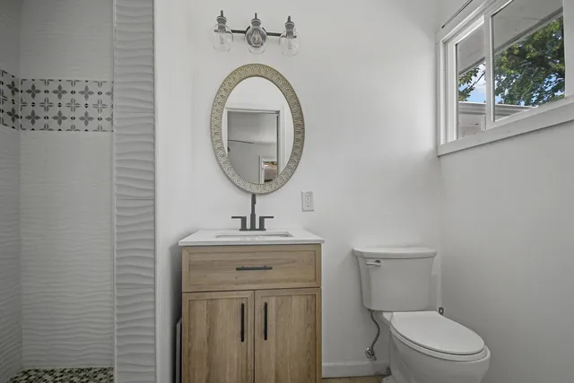 a bathroom with a toilet a sink and mirror