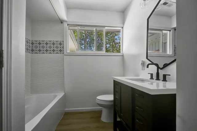 a front view of a house with a yard and trees