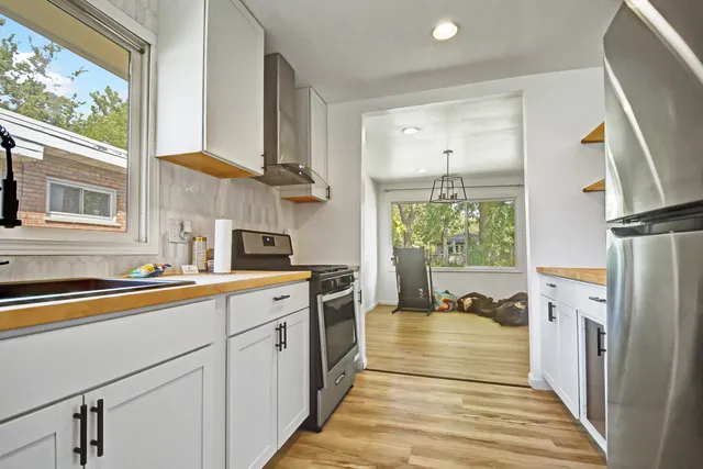 a kitchen with a sink a refrigerator and a window