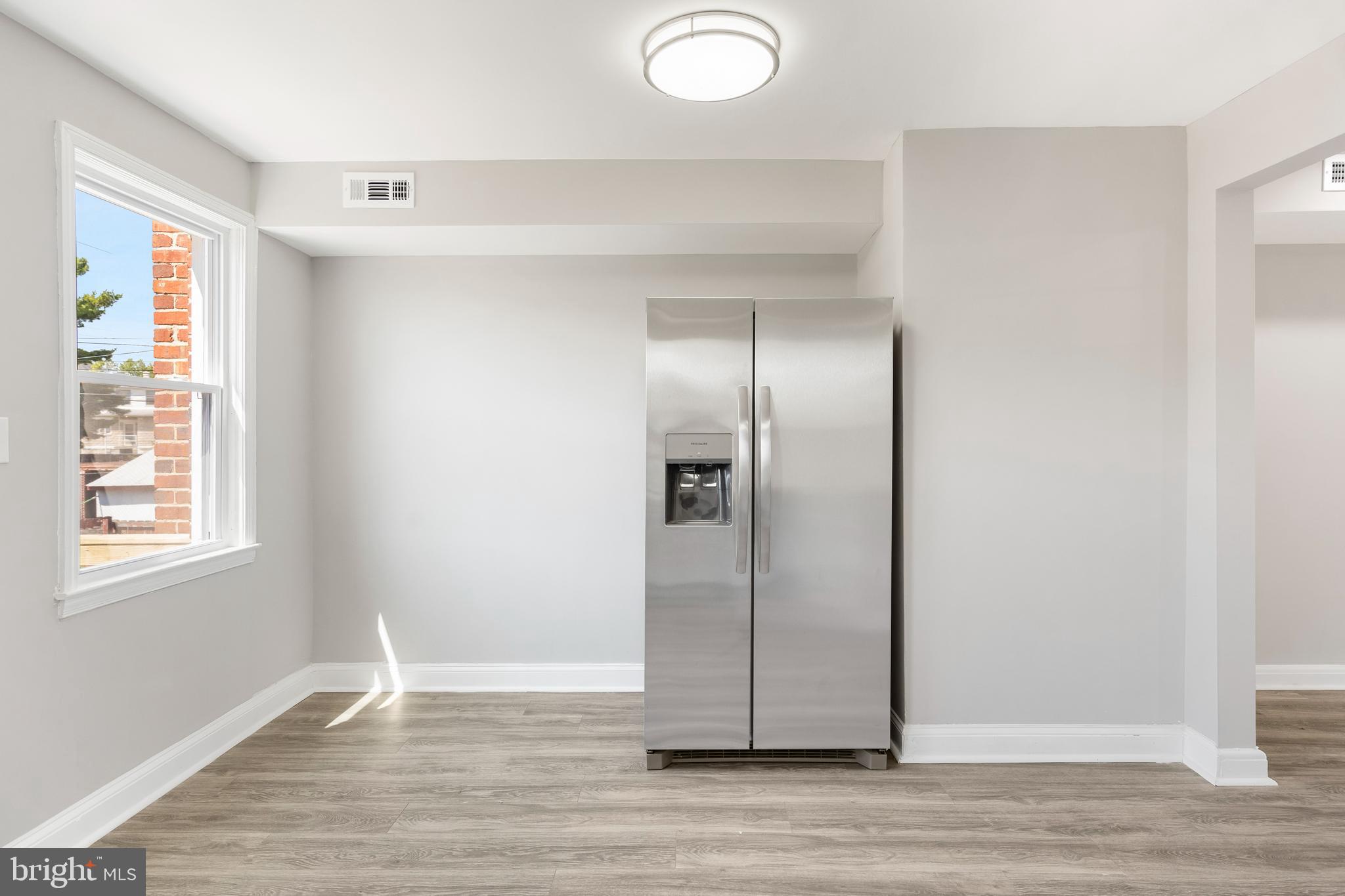 1263 Neighbors Avenue Baltimore, MD 21237 - Photo 13 of 33 an empty room with wooden floor and windows