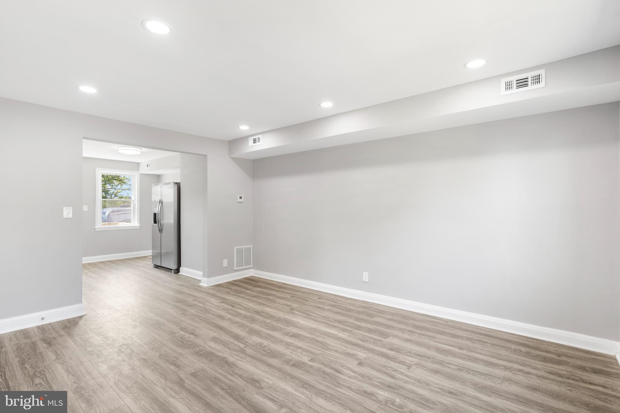 1263 Neighbors Avenue Baltimore, MD 21237 - Photo 4 of 33 a view of an empty room with wooden floor and a window