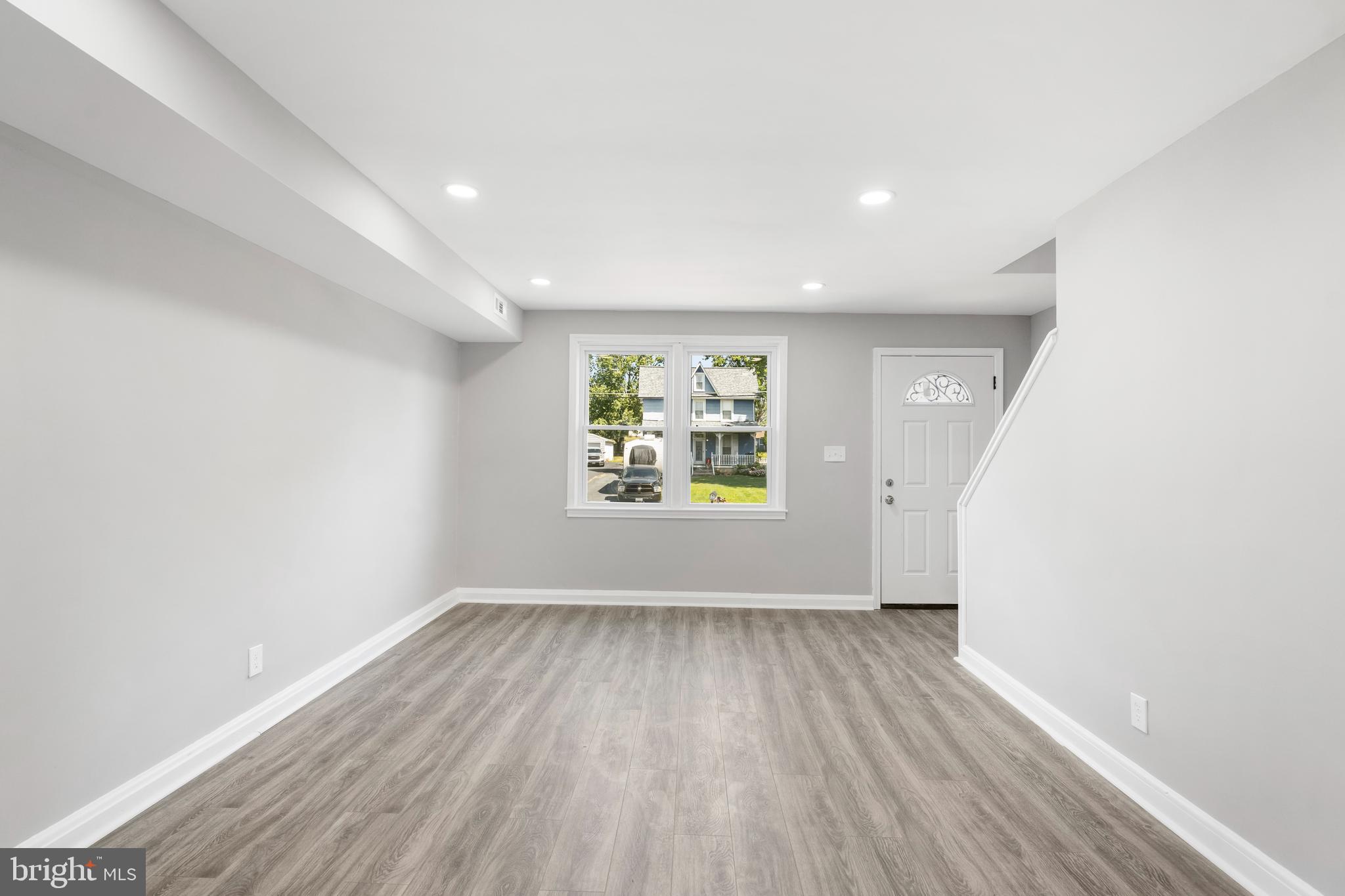 1263 Neighbors Avenue Baltimore, MD 21237 - Photo 7 of 33 an empty room with wooden floor and windows