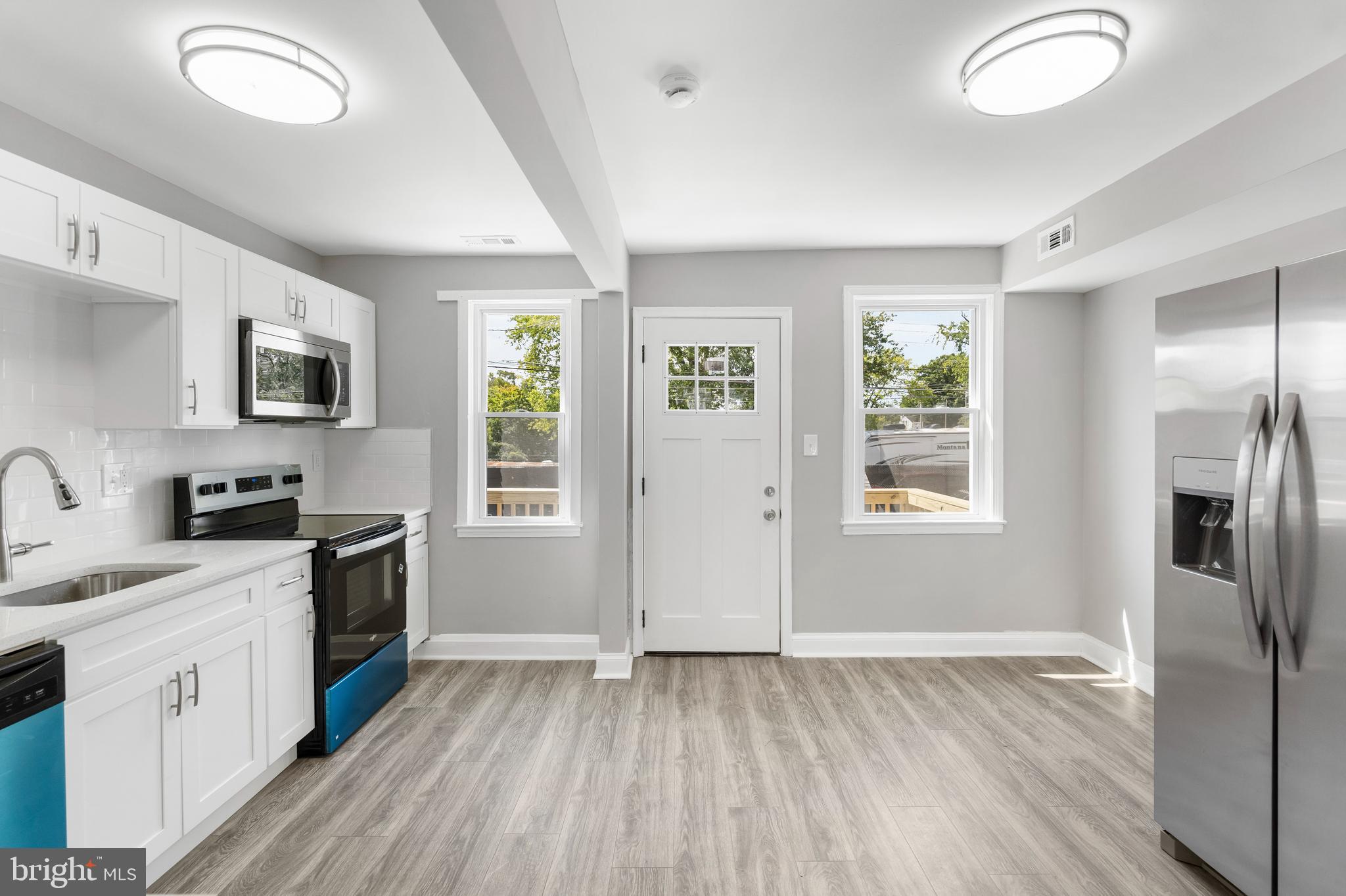 1263 Neighbors Avenue Baltimore, MD 21237 - Photo 9 of 33 a kitchen with stainless steel appliances a stove a sink dishwasher a refrigerator and a stove with wooden floor