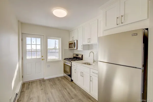 a kitchen with white cabinets and white appliances