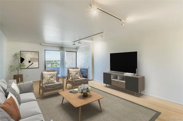 a living room with furniture a flat screen tv a rug and a window