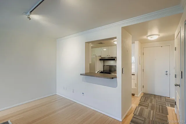 a view of a hallway with wooden floor and a bathroom