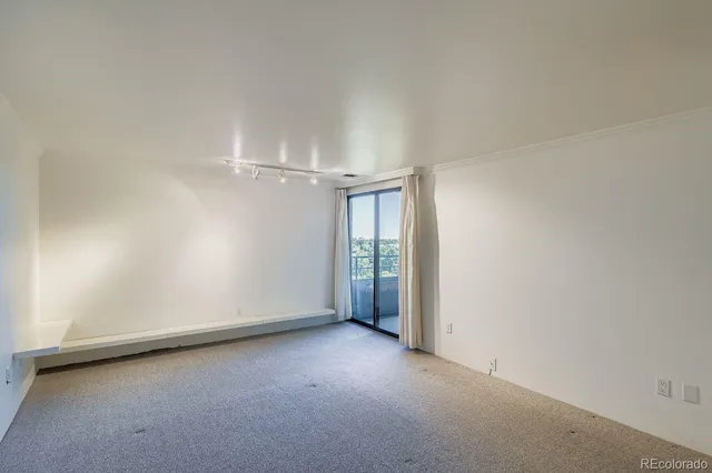 an empty room with entrance and windows