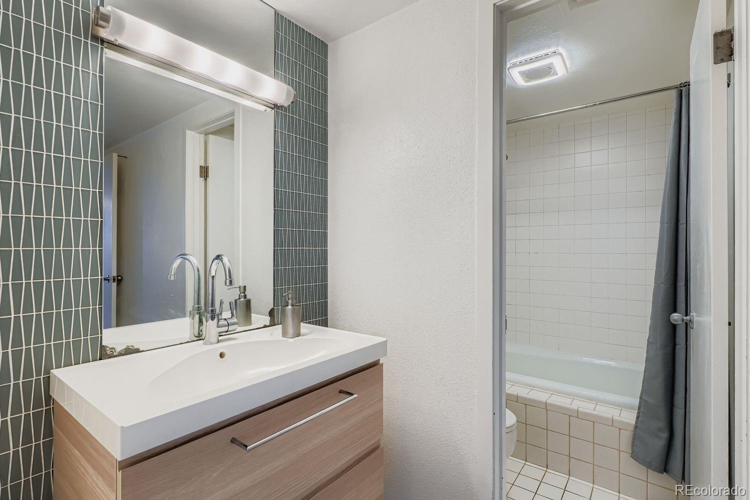 800 Pearl Street, Unit 809 Denver, CO 80203 - Photo 8 of 15 a bathroom with a sink a mirror and a shower