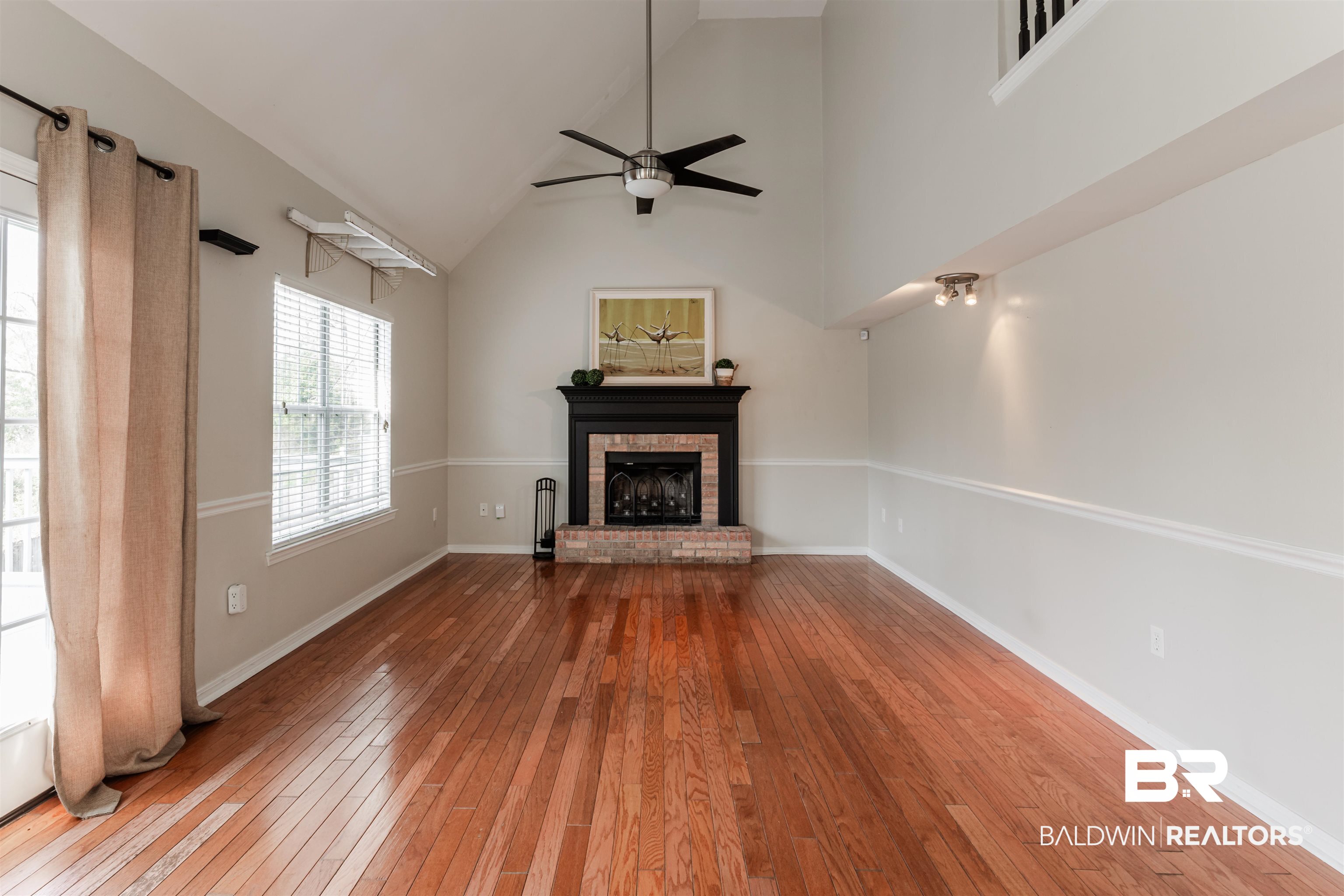 3844 Isabel Way South Mobile, AL 36693 - Photo 18 of 49 Unfurnished living room with hardwood / wood-style floors, a fireplace, high vaulted ceiling, and ceiling fan