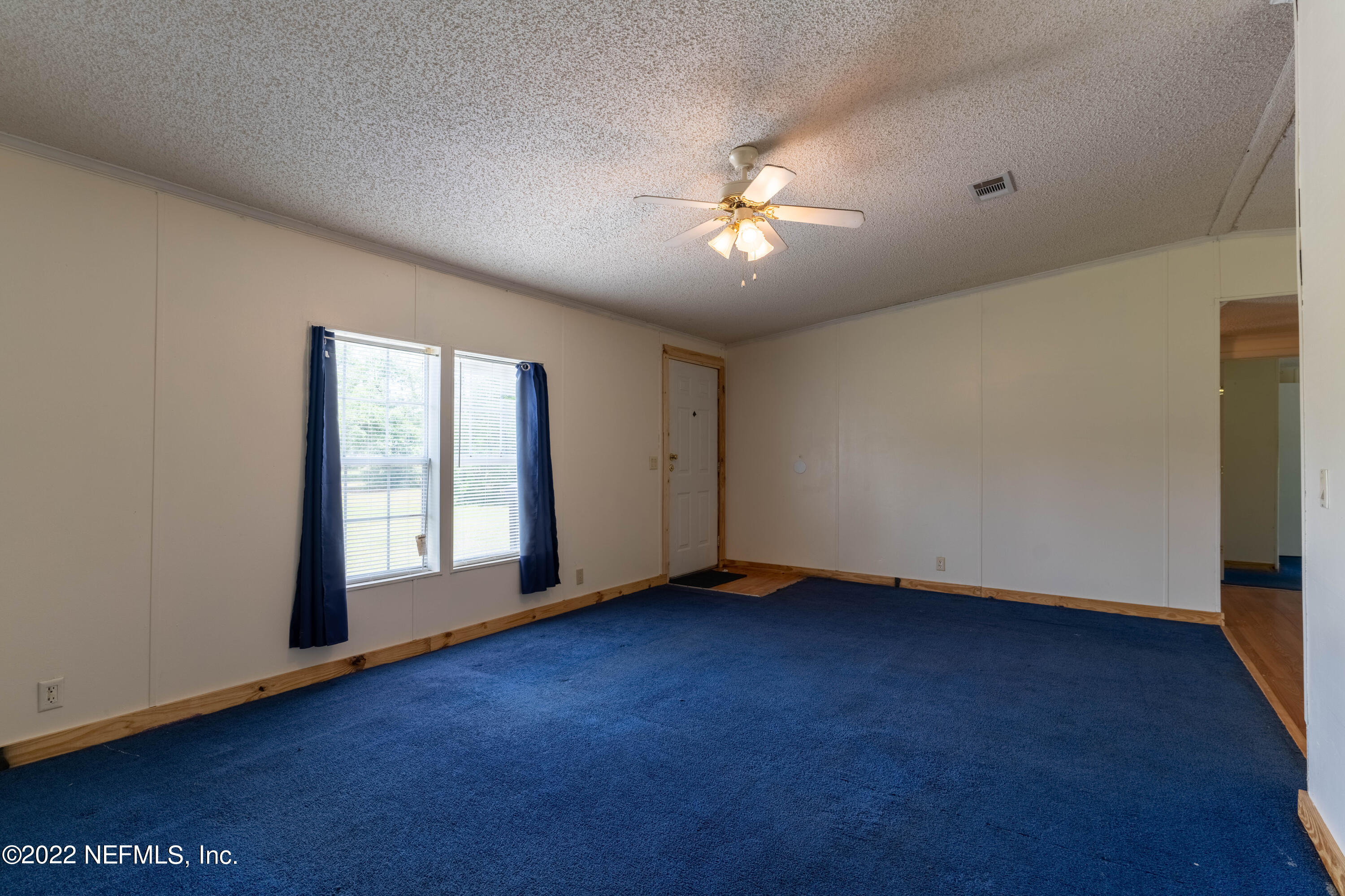 19697 Crews Road Glen St. Mary, FL 32040 - Photo 13 of 25 a view of empty room with wooden floor and fan