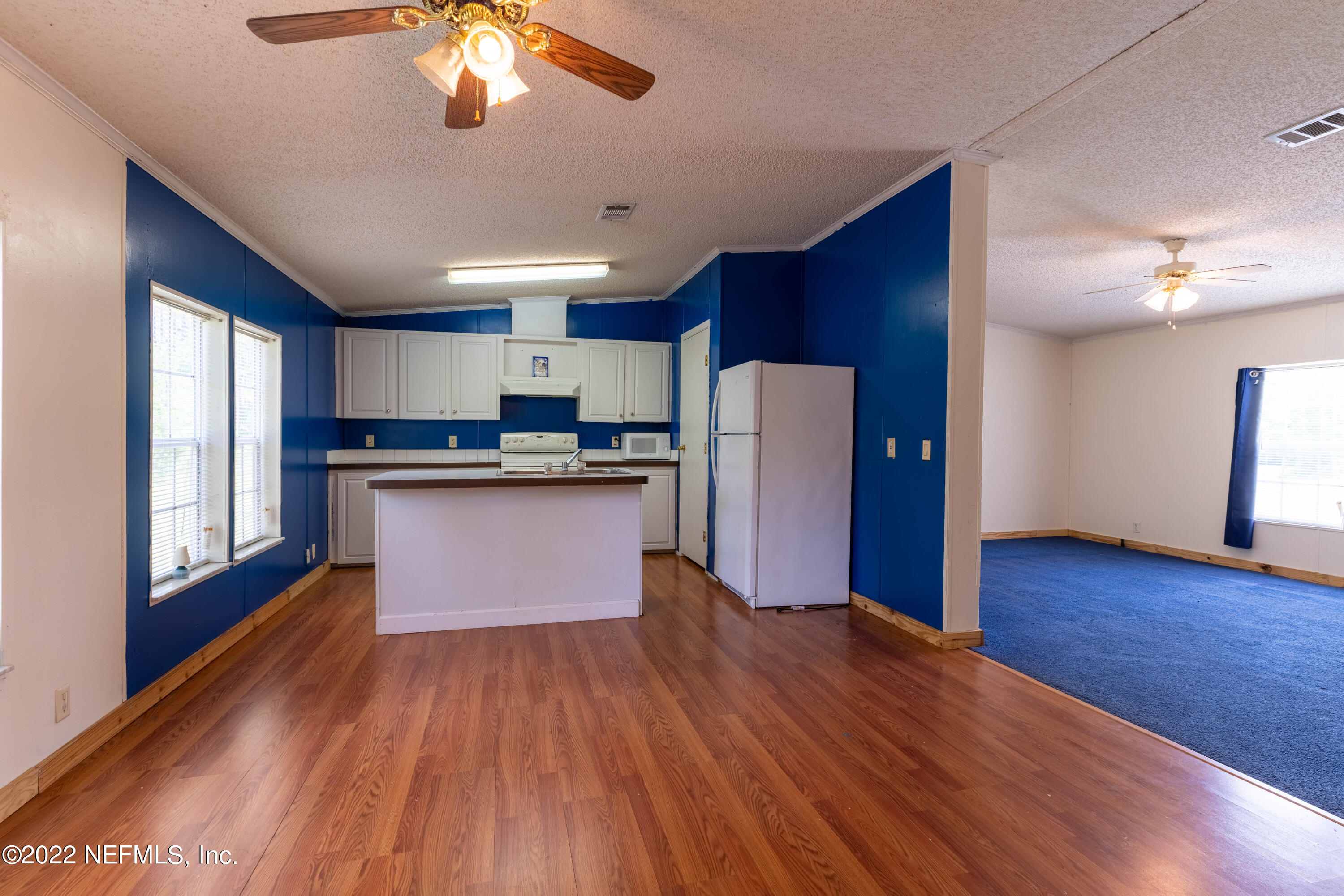 19697 Crews Road Glen St. Mary, FL 32040 - Photo 15 of 25 a kitchen with stainless steel appliances granite countertop a refrigerator a stove top oven a sink and dishwasher with wooden floor